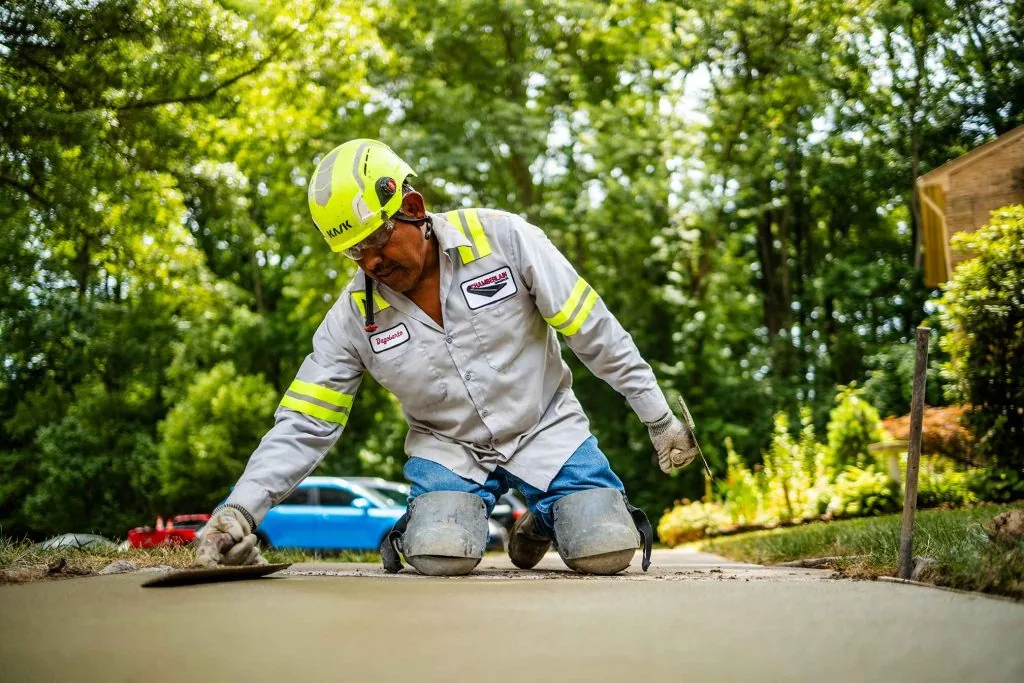 Contractor smoothing cement on a sidewalk