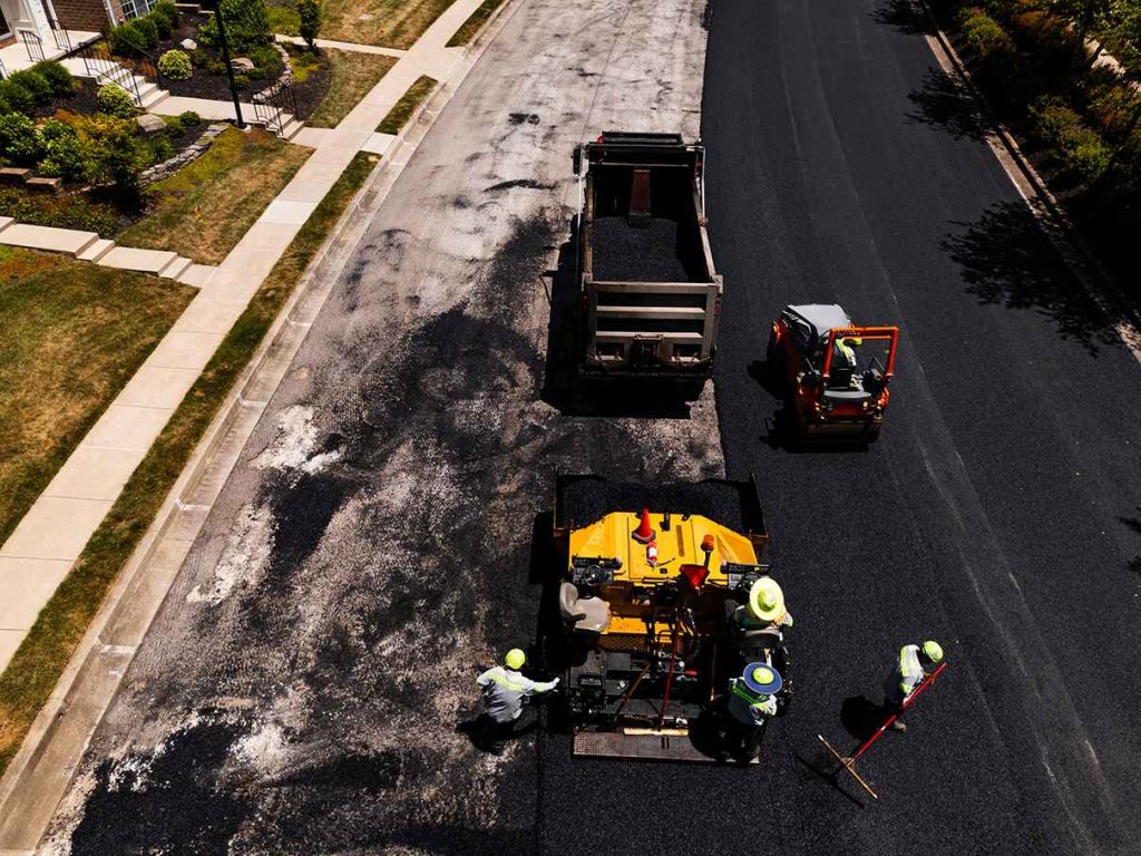 Aerial shot of contractors laying down a fresh layer of asphalt