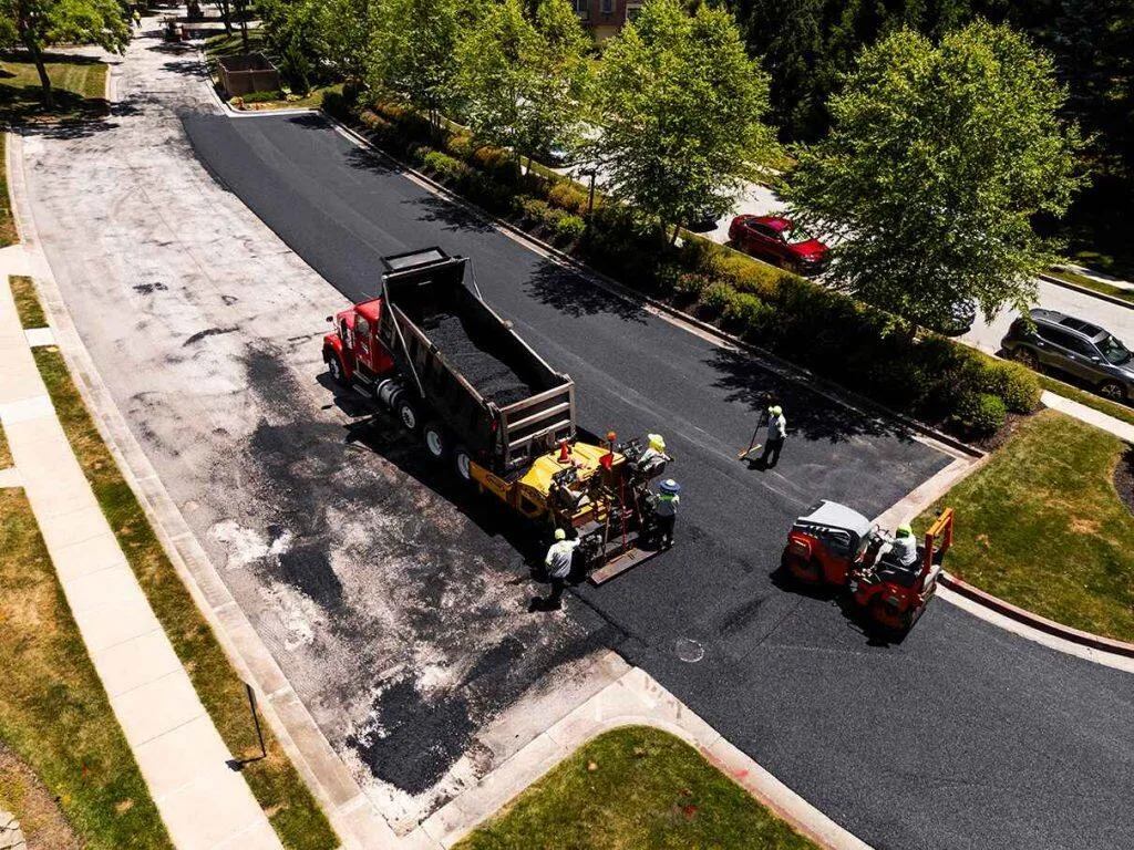 Paving contractors laying fresh asphalt down on a street