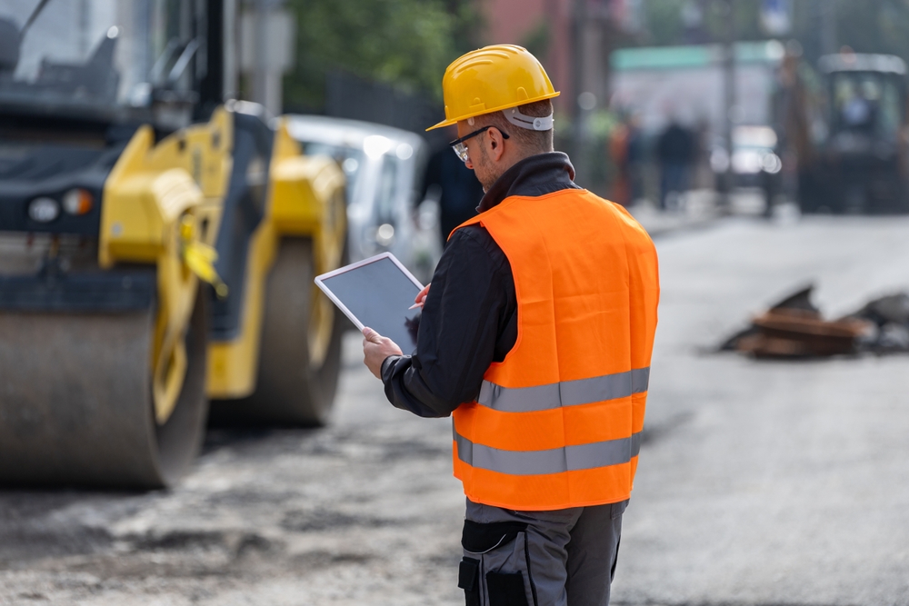 Construction worker wearing a safety helmet and reflective vest on a job site