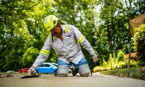 Contractor smoothing cement on a sidewalk
