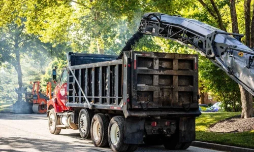 Asphalt Milling Machine Pouring Asphalt Into The Bed of a Work Truck