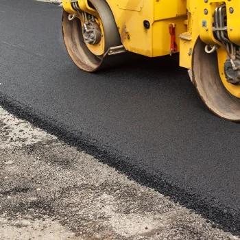 Asphalt roller compacting fresh asphalt during a pavement repair